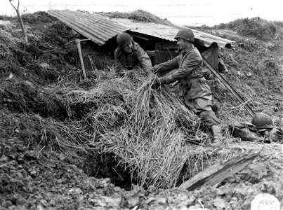 SC 195732 - This makeshift shelter is home to T/Sgt. Joe Chitwood, of Ironton, Mo., and Pfc. Francis Tuberville of Marton, S.C., as they improvise protection from the mud and rain. Near Nancy, France. 13 October, 1944.