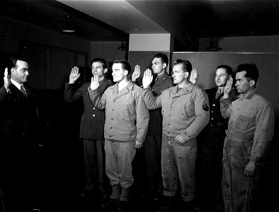 SC 364421 - Charles W. Donoghue of Boston, Mass., naturalization examiner for the Dept. of Justice, gives the oath of allegiance to six soldiers of the United States Army, who became citizens while serving at an army post somewhere in Newfoundland.