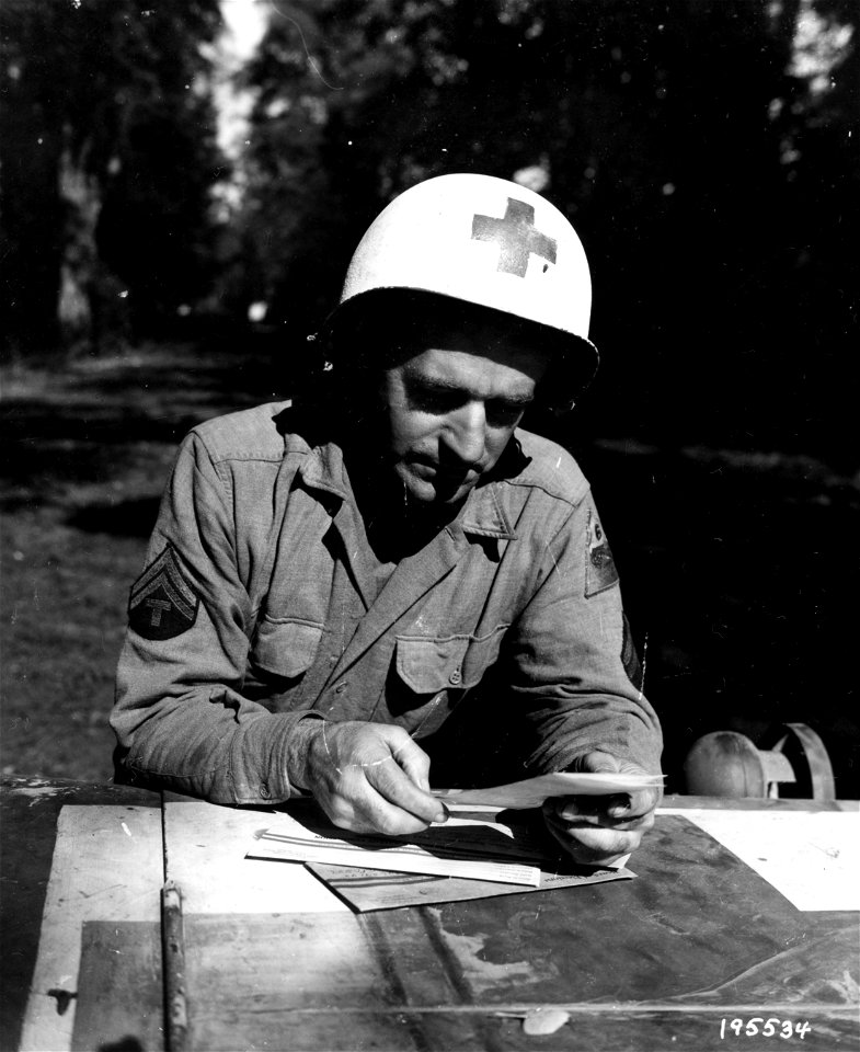 SC 195534 - Cpl. John M. Rhodes, using the hood of his jeep as a table, pores over his soldiers' ballot.