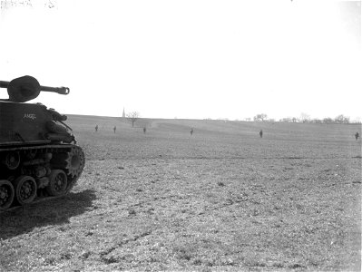 SC 270642 - 7th U.S. Army infantrymen advance up hill towards Wetzhausen, Germany, while tanks wait to move up with other troops. 9 April, 1945. photo
