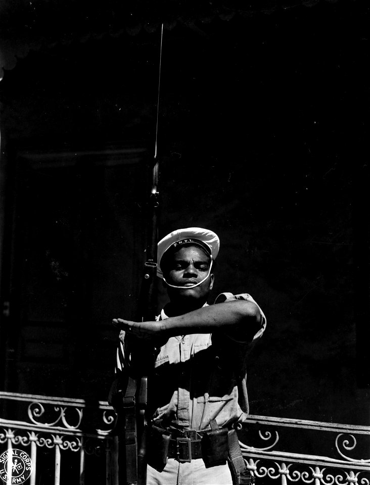 SC 364412 - Native Melanesian of New Caledonia, wearing the uniform of a French sailor, stands guard before French Navy Hq. in Noumea, largest town in New Caledonia.