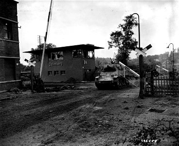 SC 335555 - The American armor moves forward through the shattered railway station at Palenberg, Germany, in pursuit of retreating German army units.