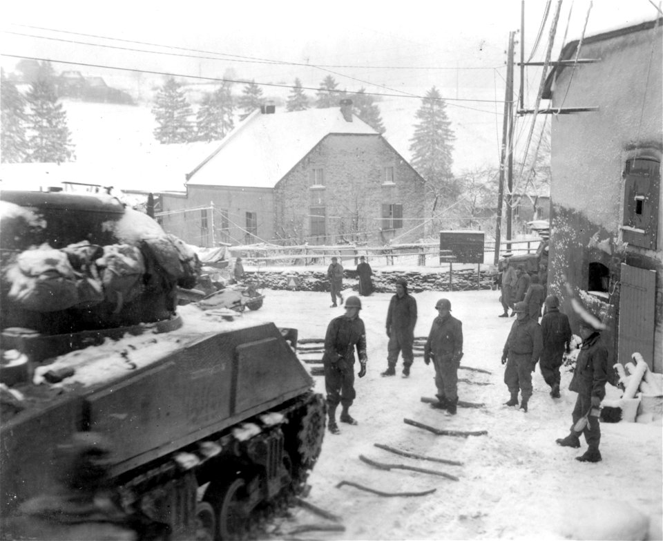 SC 329969 - When tanks of the 35th Division had to negotiate steep and icy roads in the outskirts of Bastogne, Belgium, tank crew members placed lengths of firewood on the road for increased traction. 4 January, 1945.