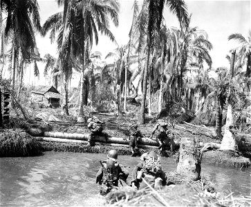 SC 195585-S - A water tank trap, one of the many futile attempts made by the retreating Japanese on Leyte Island to retard the onslaught of the American invasion, is crossed by members of the famed U.S. 1st Cavalry Division. October, 1944.