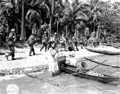 SC 196096-S - Men of the 24th Division march past Filipinos on the beach at Leyte Island, P.I.