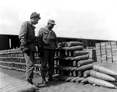 SC 364048 - Lt. William J. Gaines, Newport, RI., and Lt. Frank James, Wharton, Texas, both of the 630th Ord. Ammo Co., examine nose plugs on 155 mm shells at 630th Ord. Ammo Depot in Seoul, Korea. photo