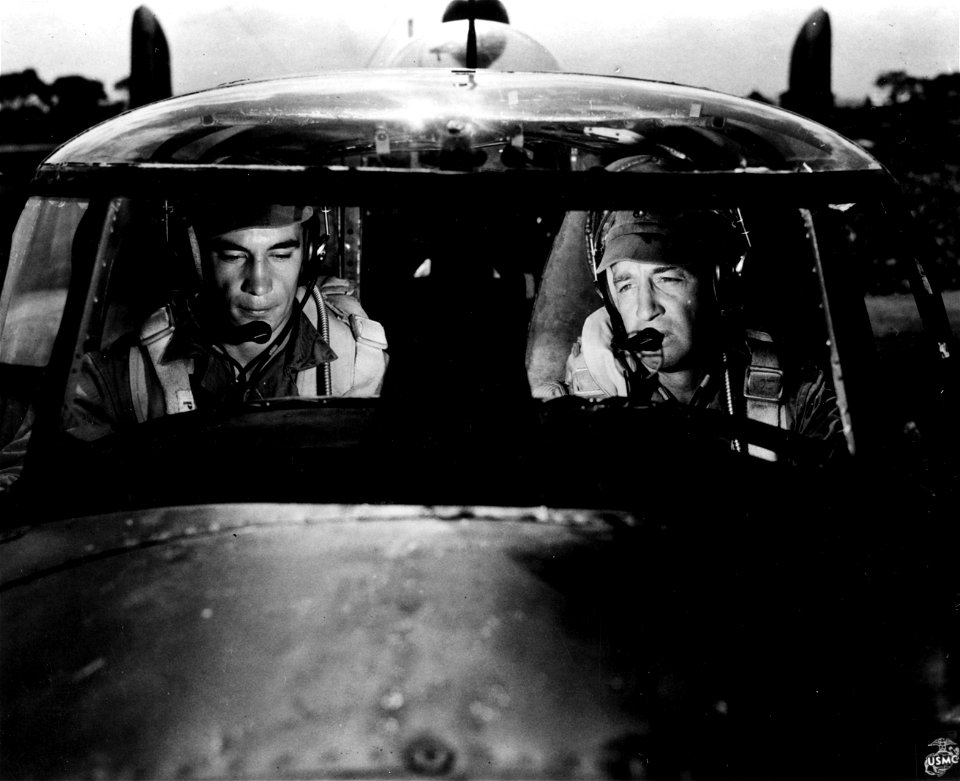 Lieutenant Colonel Jack R. Cram, right, gives last-minute instructions to his crew before leading the squadron on a night strike at Jap shipping.