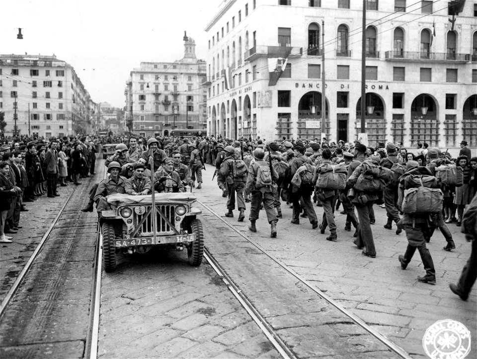 SC 337141 - 92nd Div. troops riding down street in newly-liberated Genoa pass PWs going to the rear. 21 April, 1945.