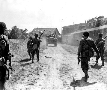 SC 337265 - After a frontal attack routed the Nazis from Angers, tanks with infantrymen walking alongside, move through the town. photo