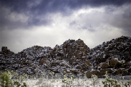 Clouds over snow-dusted rock formations photo