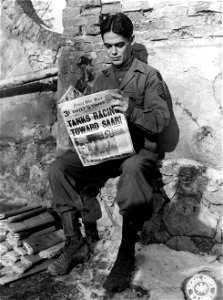 SC 396920 - News of homefront activities is read by Sgt. Timothy J. Flynn, 210 W. St., St. Paul Avenue, Chicago, Ill., as he looks through a copy of the Daily Times.