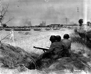 SC 364273 - Chartres Cathedral, the jewel of Christian civilization, still looms in the background as American infantrymen wait for the artillery to soften up German positions so they may go in and fight for that very civilization.