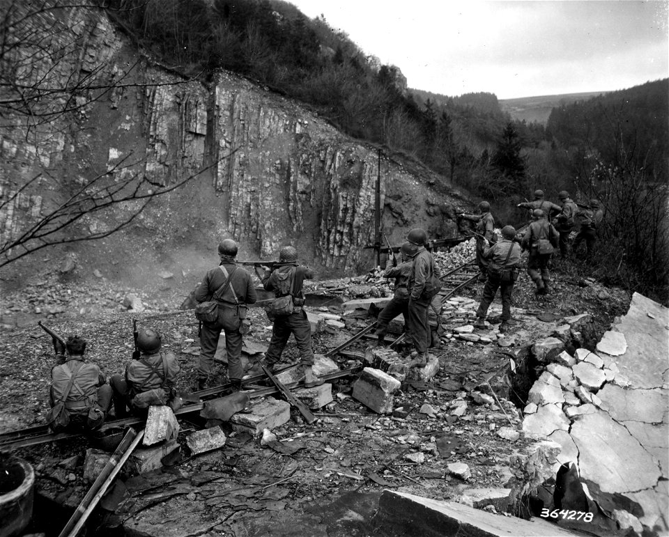 SC 364278 - Infantrymen attached to 3rd Armored Division fire weapons in abandoned quarry before they go up to the front.  30 November, 1944.