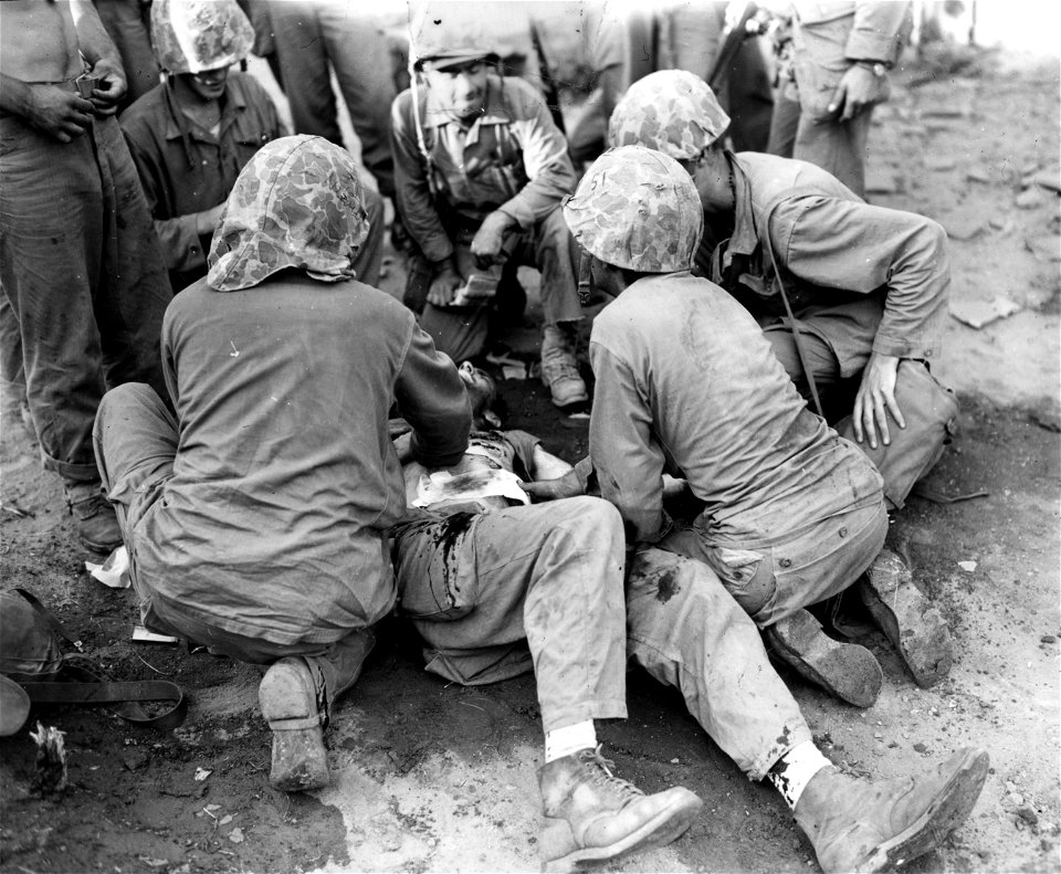 SC 348677 - A group of Marine medics giving aid to a wounded Marine at Sosa-Ri, Korea. Marine was wounded by mortar fire. 19 September, 1950.