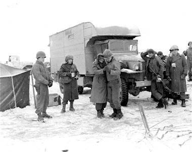 SC 199034-S - A Red Cross girl dances with men of the 919th Field Artillery Battalion during a break in firing near Tunting, France. 22 January, 1945. photo