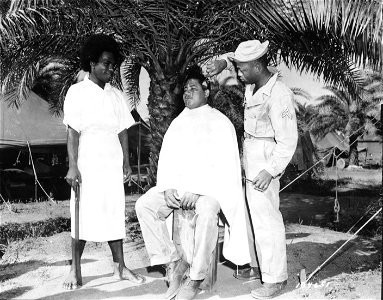 SC 184651 - Sgt. Walter Rothschild of Birmingham, Ala, gets a "G.I." haircut while a Fijian native awaits his turn in the chair. photo