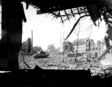 SC 336818 - Schweinfurt: Long Yank-carrying American tank plows its way through bomb-shattered section of Schweinfurt.