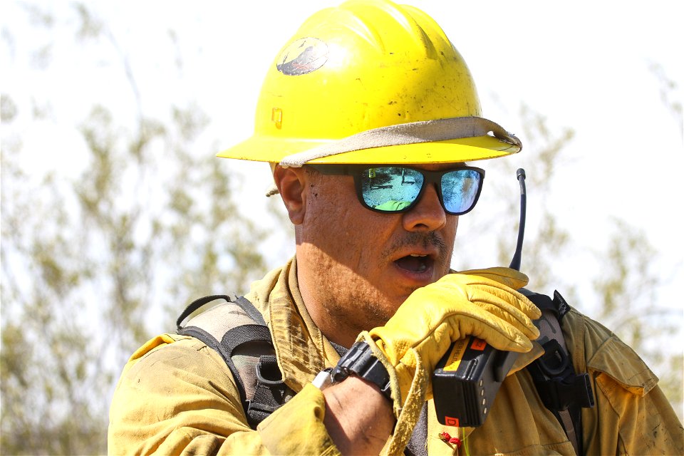 MAY 19: Using a radio during mop up of brush fire photo