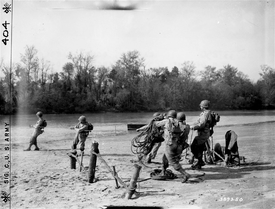 SC 337250 - Men of the 325th Engineering Battalion stretch rope for a footbridge across the Wateree River, five miles west of Camden, South Carolina. 30 October, 1943.