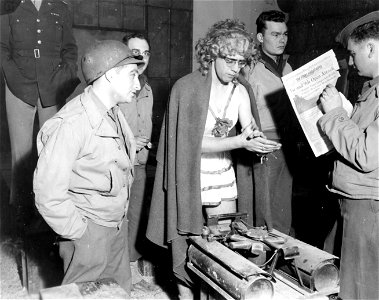 SC 198860-S - T/5 John M. Moncrief, Jr., of 1748th E. 14th Pl., Tulsa, Oklahoma, warms himself near stove unit behind scenes of "You've had it," musical comedy presented by 3103rd Signal Service Battalion at Verdun.