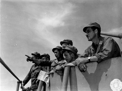 SC 184744 - Capt. Elmer O. Navarro, troop commander and CO of G Co., 126th Inf. of 32nd Div., explains to his officers a last minute change of plan.