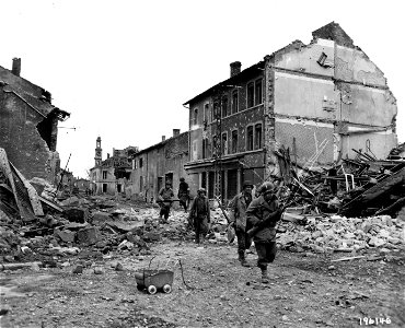 SC 196146 - A squad of infantrymen patrol through the streets of the shattered town of Maizieres-les-Metz, France, on the hunt for any remaining enemy snipers. photo
