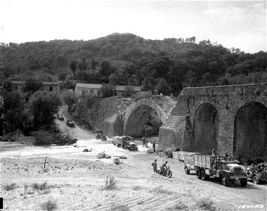 SC 180053 - Fording a stream below a bridge blasted by retreating Nazis, near Oliveto Citra, Salerno, Italy. 27 September, 1943.