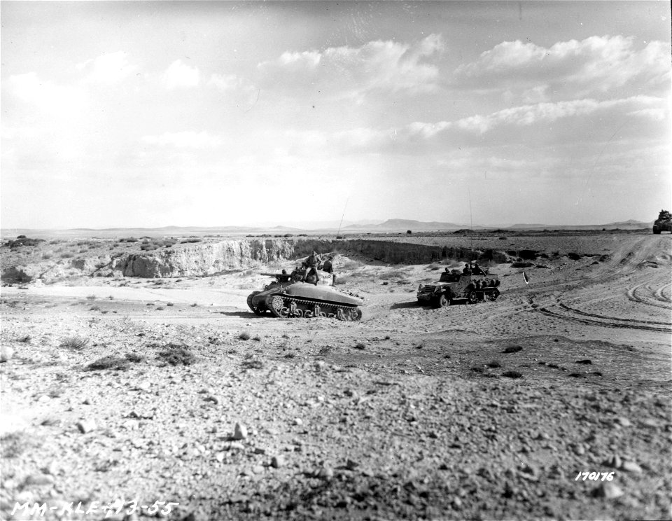 SC 170176 - An American tank pulling an American half-track over a river bed. Sidi Bou Zid, North African. 14 February, 1943.