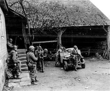 SC 336911 - Men in yard direct covering fire on enemy while tank retrieves two men pinned down by machine gun fire. photo