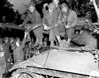 SC 329775 - Dee Kurtz, York, Pa., gives out doughnuts to a tank crew somewhere in France. 1 October, 1944. photo
