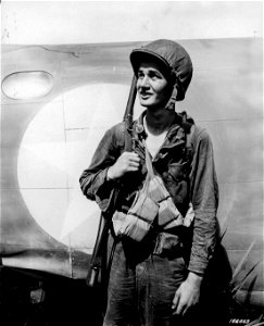 SC 166663 - A portrait of an infantry soldier - Kane, Kansas, beside a transport plane in New Guinea. 15 December, 1942. photo