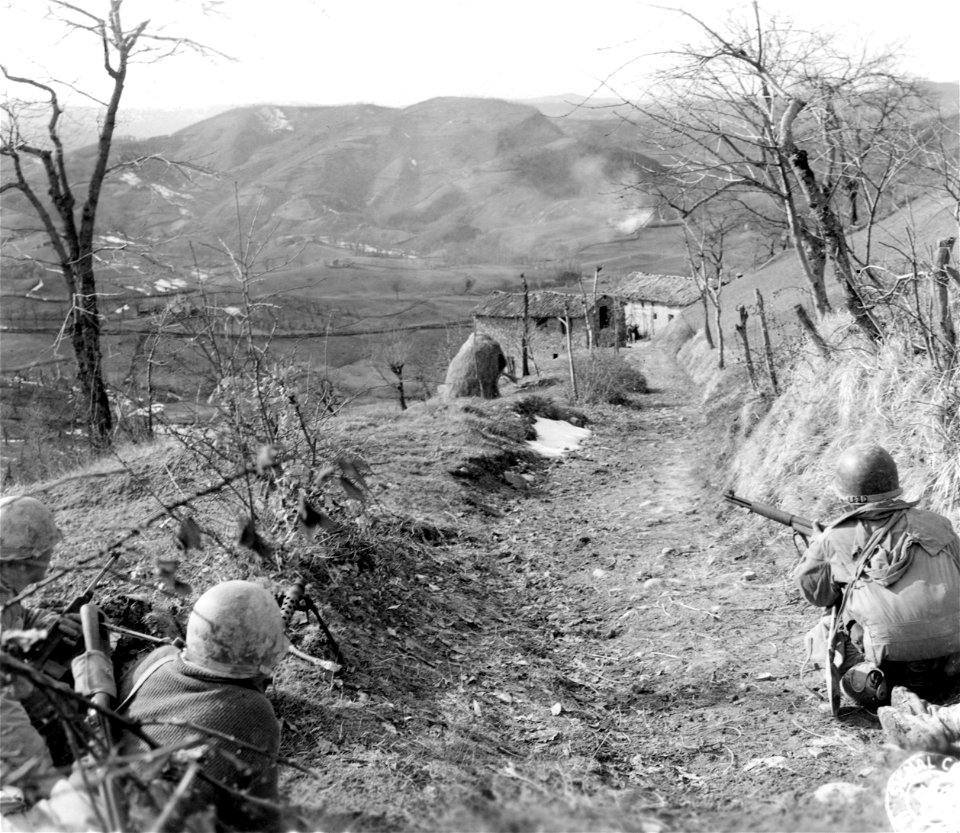 SC 270859 - Machine gunner and 2 riflemen of "K" Co., 87th Inf. Regt., 10th Mtn. Div., cover building occupied by 5 Germans a assault squad flushes out the Germans.