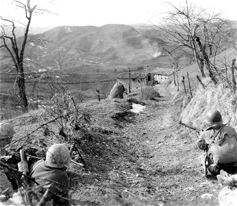 SC 270859 - Machine gunner and 2 riflemen of "K" Co., 87th Inf. Regt., 10th Mtn. Div., cover building occupied by 5 Germans a assault squad flushes out the Germans. photo
