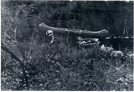 Native American portaging a canoe in Basswood River Area, 1910-1912