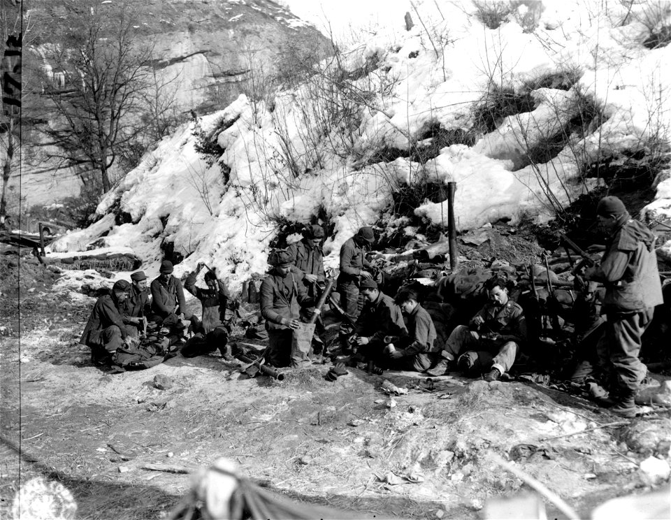 Infantrymen of 1st Platoon, Co. B., 135th Regt., 34th Div., ready their equipment and check their ammunition and supplies in preparation to move into the front line to relieve another co.