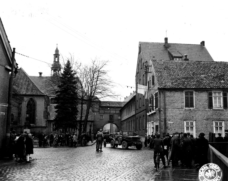 SC 336903 - Townspeople line streets as vehicles and troops of the Ninth U.S. Army pass through the German town of Wiedenbruck in pursuit of fleeing Nazis. 2 April, 1945.