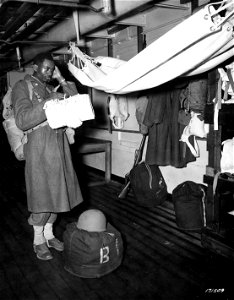 SC 171509 - Pvt. Robert A. Williams of Clarksdale, Miss., as he contemplates sleeping in a hammock aboard the transport on which his unit embarked for overseas.