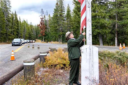 Northeast Entrance Road Improvement Reopening day October 15, 2022: Ranger raises the flag photo