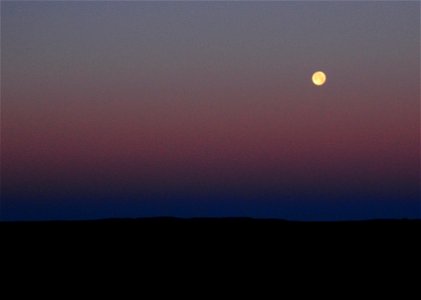 Strawberry moon setting over sage steppe at Seeskadee National Widlife Refuge Wyoming photo