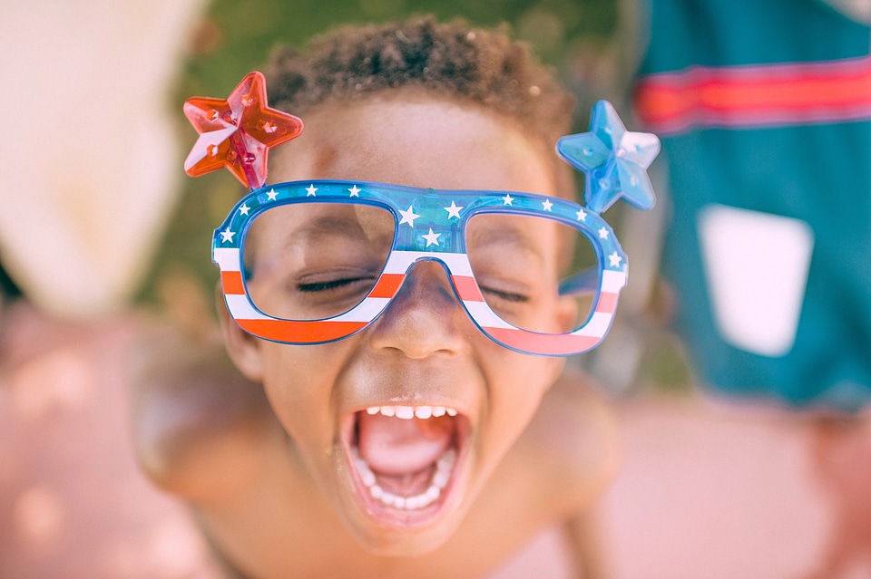 Kid Celebrating 4th of July with red white blue glasses