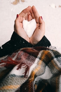 Hand holding White Snow in Heart shape photo