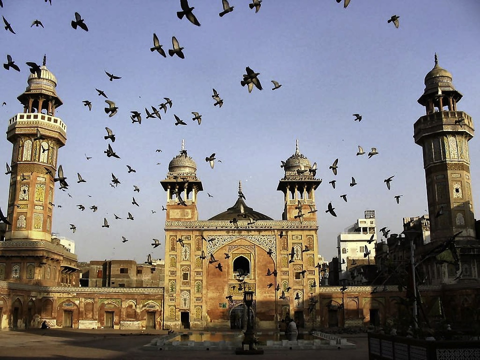 Pigeons flying over Wazir Khan Mosque in Lahore, Pakistan