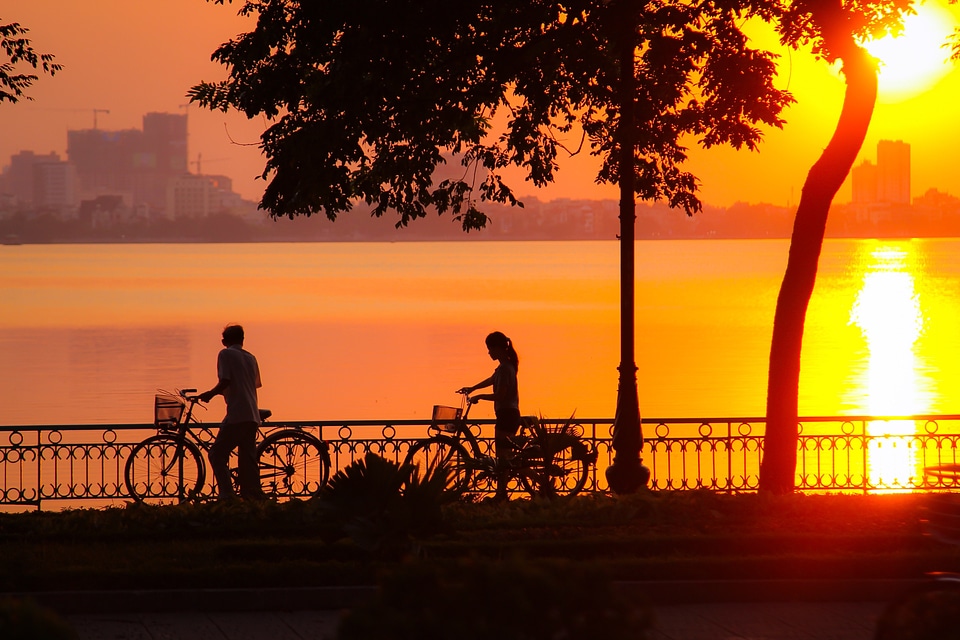 Sunset and 2 cyclists in Hanoi, Vietnam