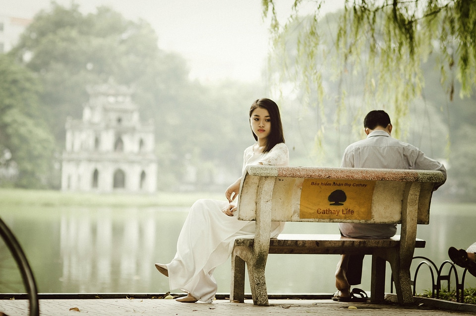 Couple sitting on a bench at Ho Guom at Hanoi, Vietnam
