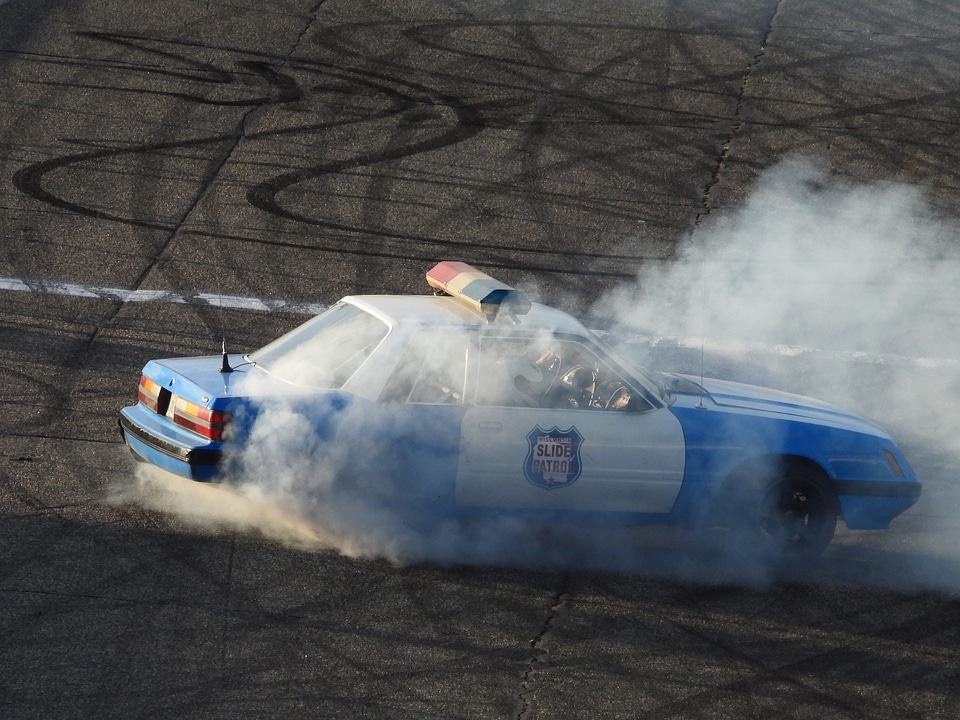 Spinning of old police car burning rubber