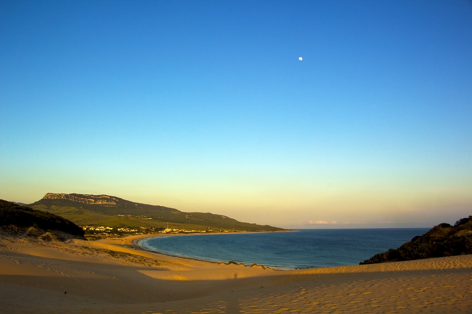 Beach landscape with moon in blue sky