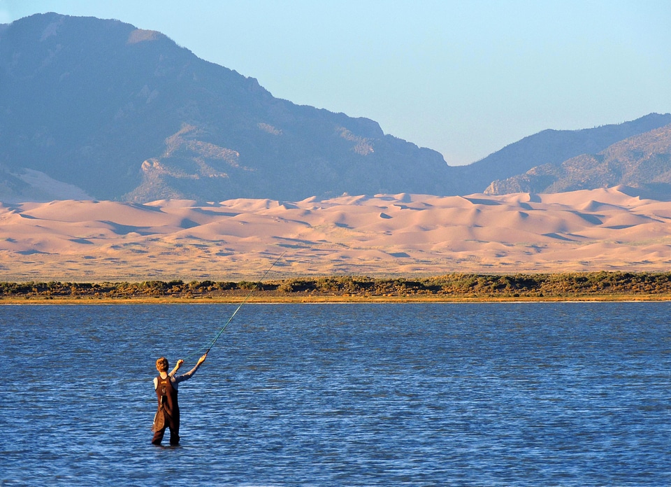 Man fishing while standing in the lake