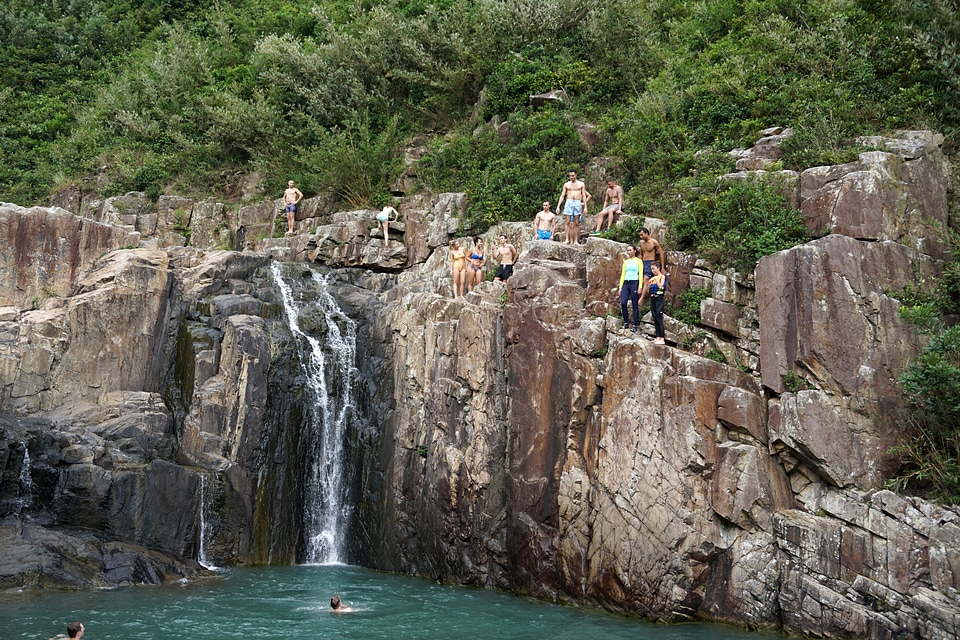 People swimming under the waterfall