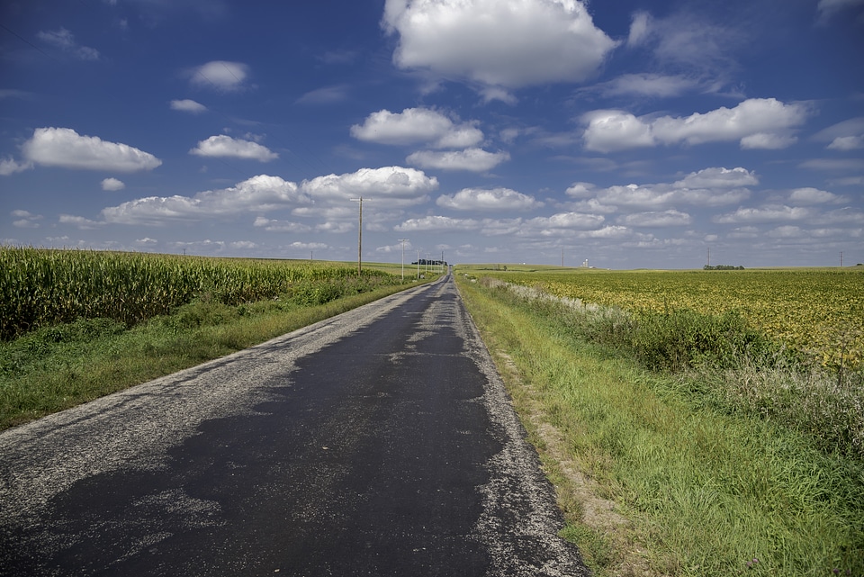 Roadway landscape under puffs of clouds