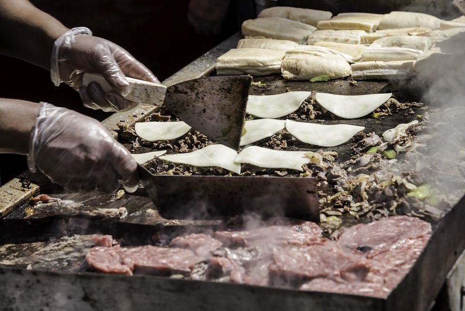 Hands preparing hamburgers and tacos at Taste of Madison